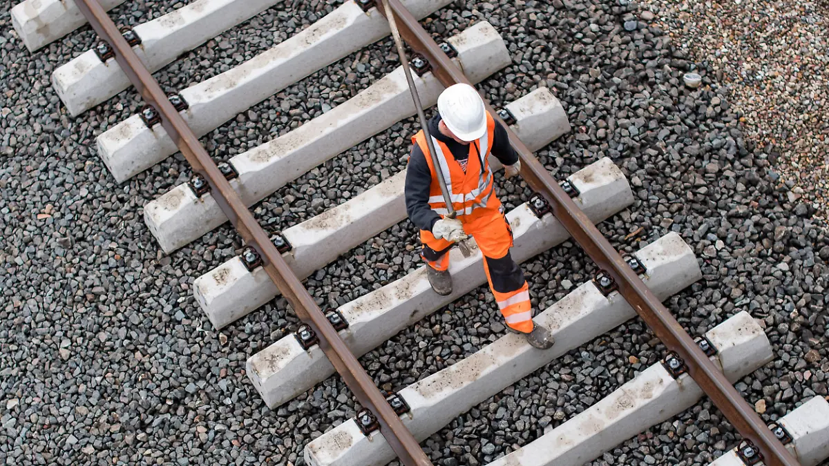 ARCHIV - 27.05.2016, Hamburg: Ein Arbeiter geht im Stadtteil Wilhelmsburg über eine noch nicht fertige Gleisanlage der Bahn. Am 30.01.2019 findet ein Treffen zur Bahnkrise bei Bundesverkehrsminister Scheuer statt. Foto: Lukas Schulze/dpa +++ dpa-Bildfunk +++