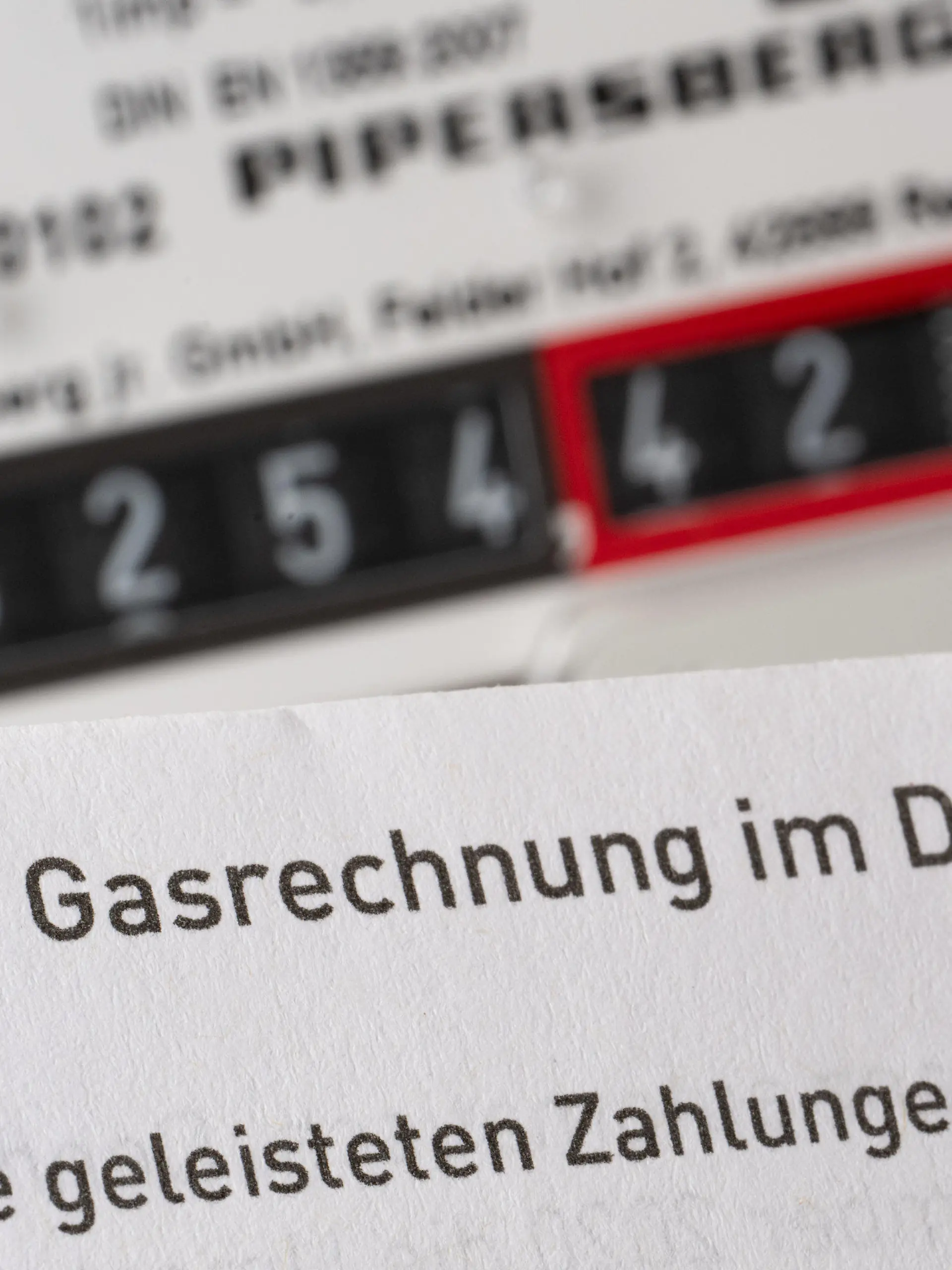 11.07.2022, Baden-Württemberg, Stuttgart: Eine Gasrechnung wird in einem privaten Haushalt vor einem Gaszähler gehalten (gestellte Szene). Der Städtetag hat in Bezug auf den drohenden Gasmangel und die Maßnahmenpläne der Kommunen Gespräche in Berlin geführt, über die nun berichtet wird. Foto: Bernd Weißbrod/dpa +++ dpa-Bildfunk +++