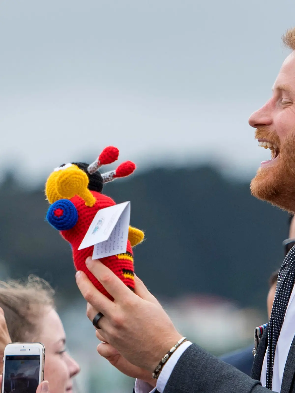 ARCHIV - 28.10.2018, Neuseeland, Wellington: Prinz Harry, Herzog von Sussex, wird während eines öffentlichen Rundgangs bei einem Besuch des neu enthüllten britischen Kriegsdenkmals und des Pukeahu National War Memorial Park ein Buzzy Bee Plüschtier gegeben. Trotz der großen Entfernung wird der Nachwuchs im britischen Königshaus auch am anderen Ende der Welt bejubelt. Aus Australien und Neuseeland gingen am 07.05.2019 besonders viele Glückwünsche für Prinz Harry und Ehefrau Meghan zur Geburt des Sohnes ein. (zu dpa "Australien und Neuseeland jubeln über Windsor-Nachwuchs") Foto: Dominic Lipinski/PA Wire/dpa +++ dpa-Bildfunk +++