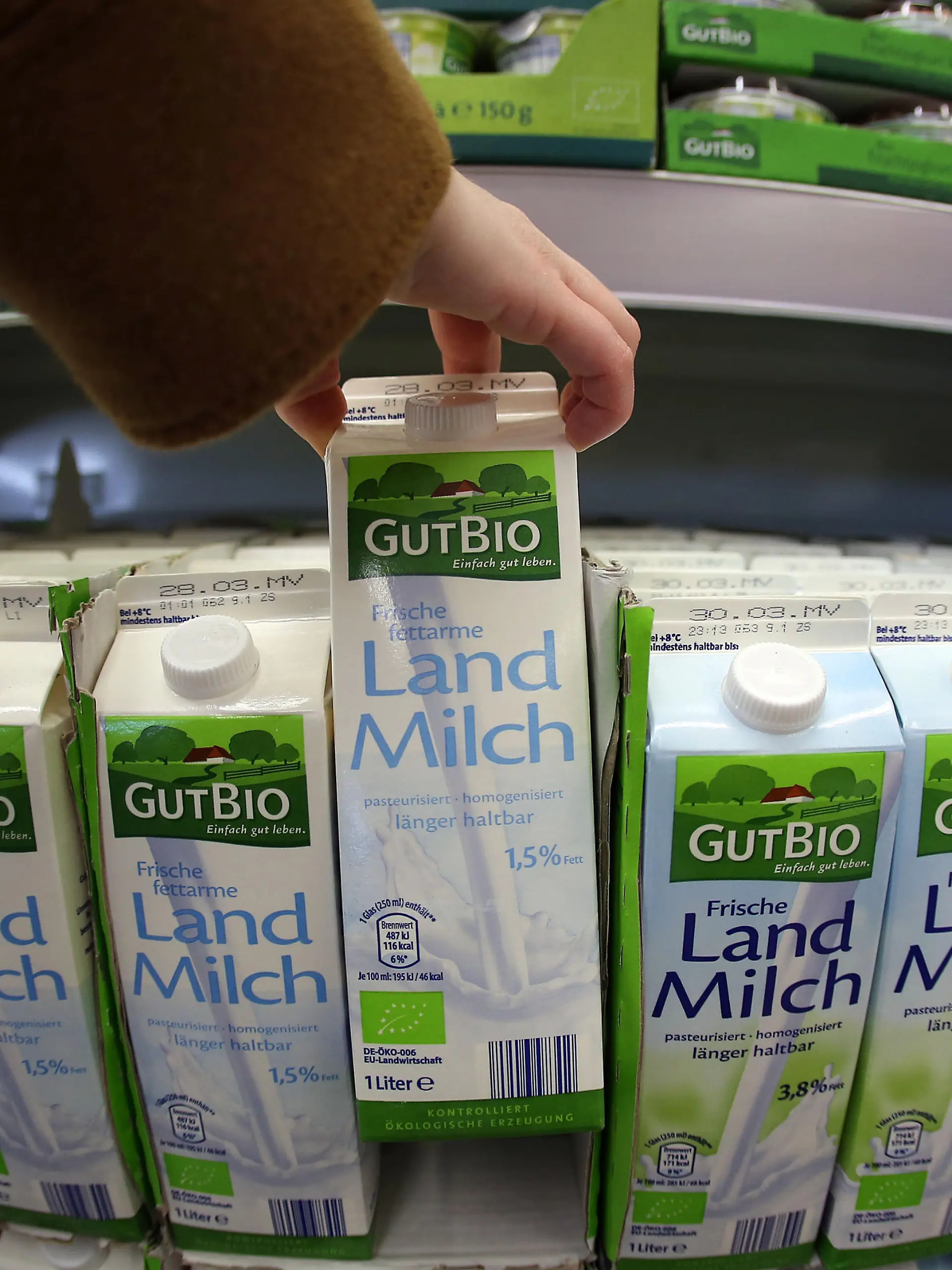 Ein Frau nimmt am 13.03.2015 in Velbert (Nordrhein-Westfalen) in einem Supermarkt von Aldi (Nord) Bio Milch aus dem Regal. Der Discounter vergrößert in diesen Wochen sein Bio-Sortiment drastisch. Unter der Eigenmarke «GutBio» sollen künftig über 50 Artikel aus kontrolliert ökologischem Anbau angeboten werden. Foto: Oliver Berg/dpa (zu dpa/lnw: "Darf es etwas mehr sein: Bioprodukte werden immer beliebter" vom 16.03.2015) ++