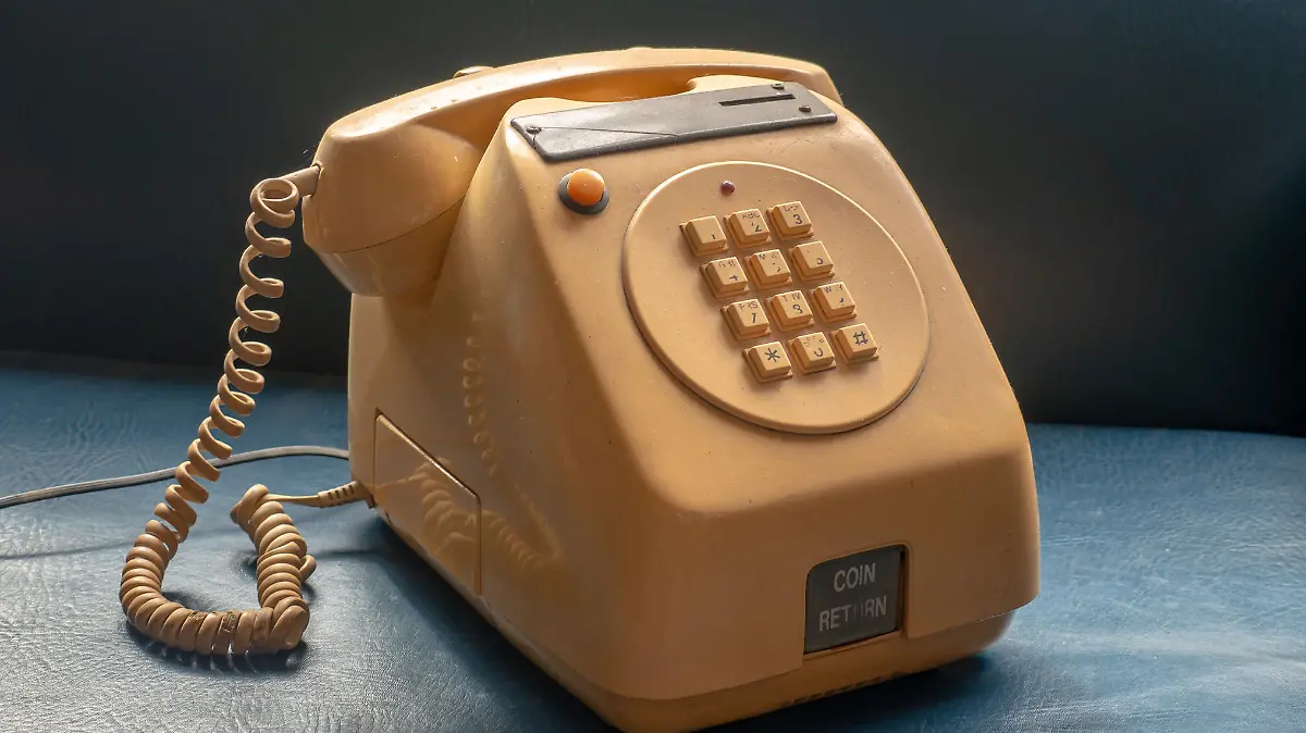 Old table version coin-operated public telephone, the kind used in bars and shops, yellow on a blue background.