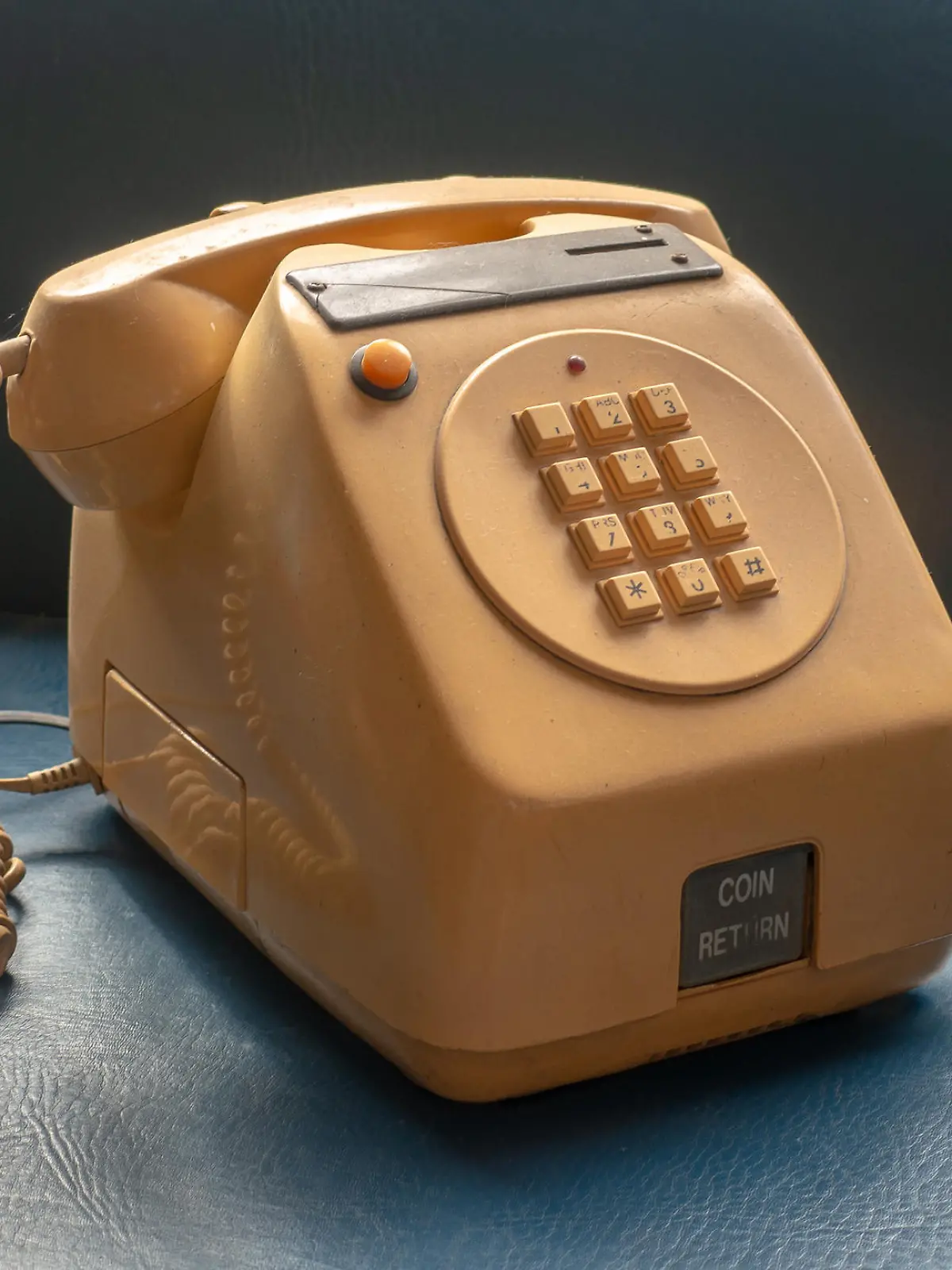 Old table version coin-operated public telephone, the kind used in bars and shops, yellow on a blue background.