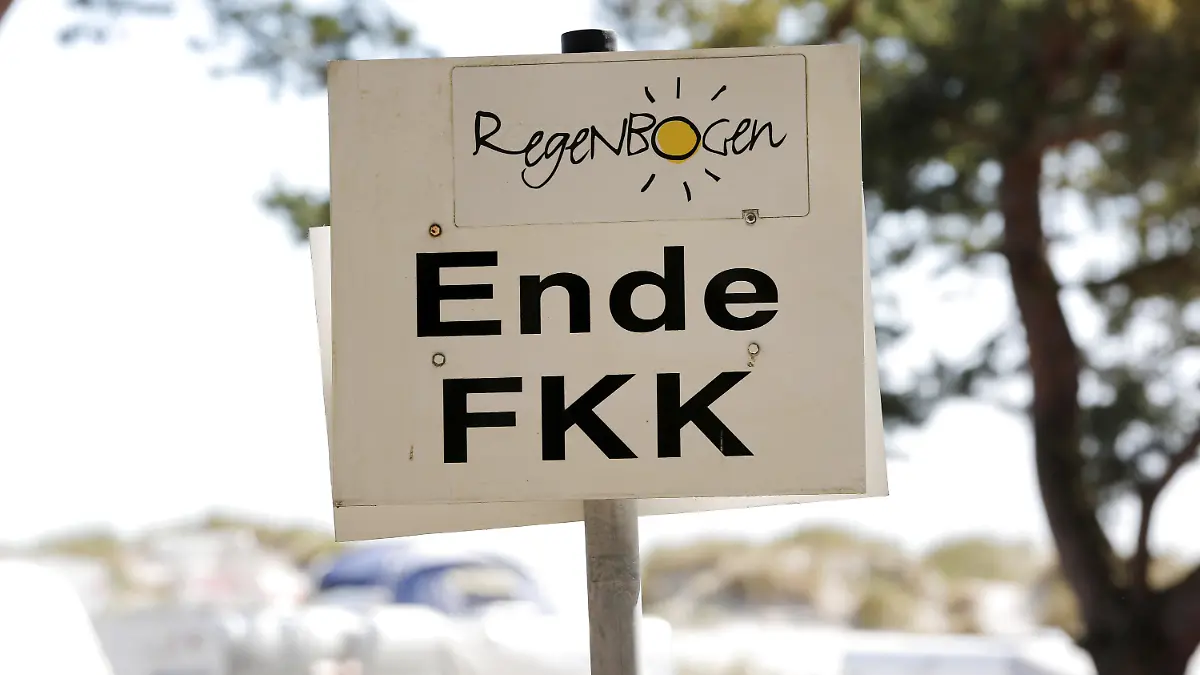 ARCHIV - 07.06.2016, Mecklenburg-Vorpommern, Prerow: "Ende FKK" steht auf einem Schild im Regenbogen-Camp auf dem Darß. Nach Expertenmeinung droht FKK in der Bedeutungslosigkeit zu versinken. Der FKK-Verband hält dagegen: Nur weil man die Nackerten nicht mehr sehe, heiße das nicht, dass es sie nicht gibt. (zu dpa "«Die nackte Wahrheit» - Wer macht eigentlich noch FKK?") Foto: Bernd Wüstneck/dpa-Zentralbild/dpa +++ dpa-Bildfunk +++