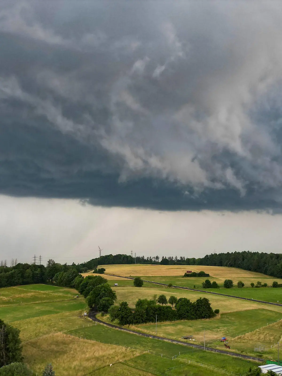 Luftaufnahme. Dunkle Wolken am Himmel wie hier in Siegen-Oberschelden. Es braut sich was zusammen. Immer wieder ziehen dunkle Wolken auf und es gibt auch immer wieder Amtliche Unwetterwarnungen vor schwerem Gewitter mit Orkanboen Orkanböen heftigem Starkregen und Hagel. Unwettergefahr im Siegerland am 22.06.2023 in Siegen/Deutschland. *** Aerial view Dark clouds in the sky as here in Siegen Oberschelden Something is brewing Again and again dark clouds move up and there are also again and again Official storm warnings of severe thunderstorms with hurricane gusts heavy rain and hail Thunderstorm danger in the Siegerland on 22 06 2023 in Siegen Germany