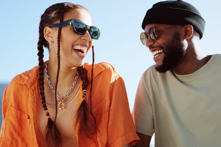 Friendship,,Flirting,And,Couple,With,Sunglasses,In,City,Sitting,On
