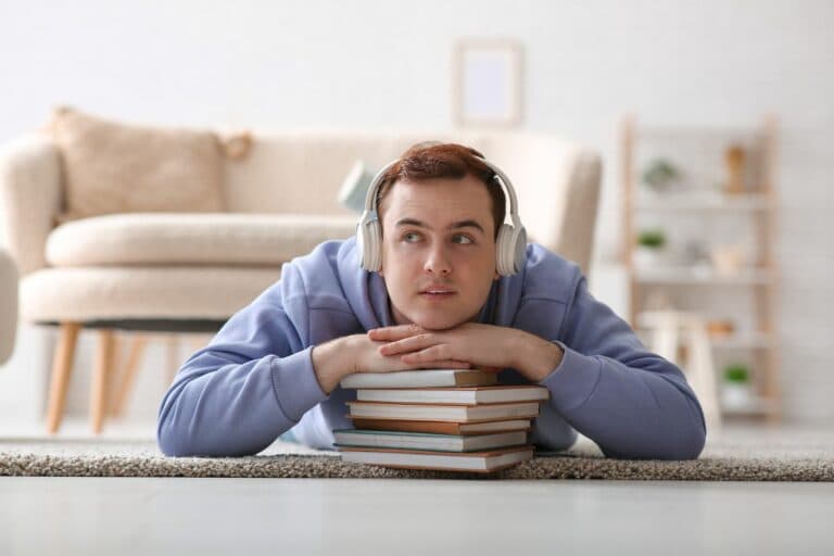 Young,Man,Listening,Audiobook,And,Resting,On,Floor,In,Living